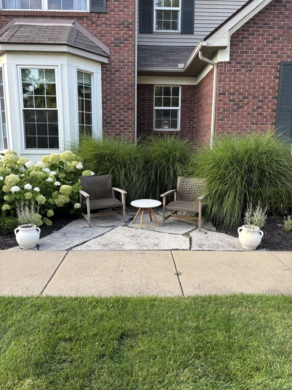 Low-maintenance landscape design with plantings, mulch, and stone